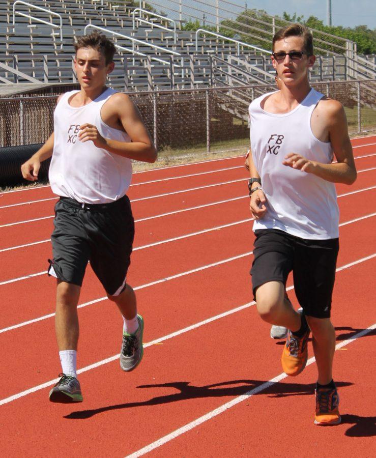 Senior Andrew Lopez-Medley and sophomore Micheal Silveus go for a cool down run after practice during seventh period on Aug. 24.