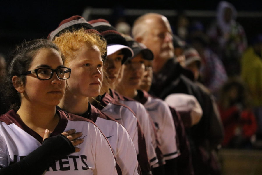 Standing at attention for the National Anthem, senior Alyx Salinas and freshman Harley Elam prepare for the game against Gregory-Portland on March 5. The Lady Hornets won 8-3.